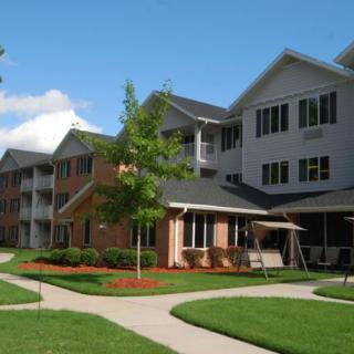 A residential apartment building with well-maintained landscaping in a suburban area.