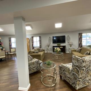 A spacious and elegantly furnished living room with modern decor, featuring sofas, a large TV, and stylish coffee tables.