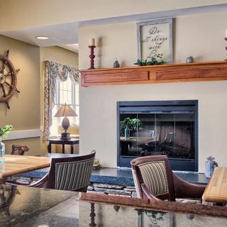 A cozy living room featuring a nautical-themed decor with a central fireplace and wooden furniture.