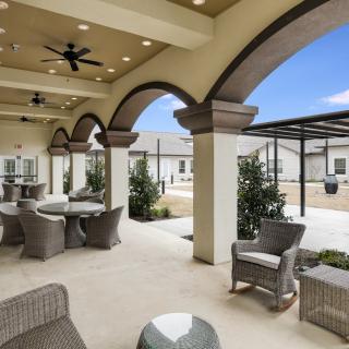 A modern outdoor patio with arched ceilings and comfortable seating.