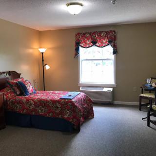 Cozy bedroom with a single bed, lamp, and window.