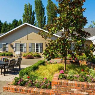 A charming house with a beautifully landscaped garden and outdoor seating area.