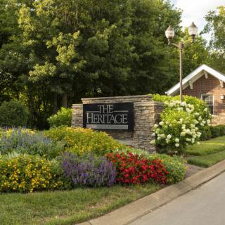 Beautifully landscaped entrance with a sign surrounded by colorful flowers and greenery.