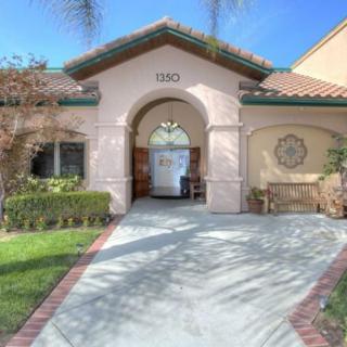 A welcoming entrance to a residential house, featuring an archway and neatly maintained landscaping.