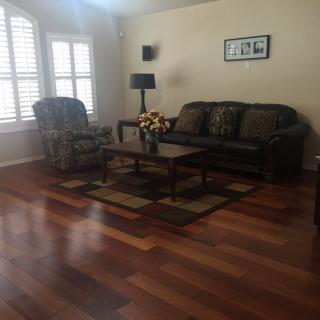 A cozy living room with a sofa, armchair, and coffee table on a hardwood floor.
