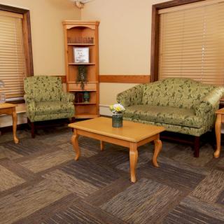 A cozy living room with green upholstered furniture and a wooden coffee table.