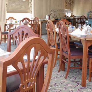 An empty restaurant dining area with wooden furniture.