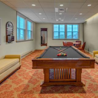 A cozy game room featuring a classic pool table and comfortable seating, perfect for leisure activities.