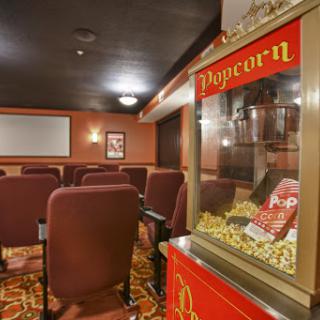 A cozy home theater setup featuring comfortable seating and a vintage popcorn machine.