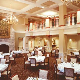 An elegant dining room setting with beautifully arranged tables and chandeliers.