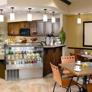 A cozy cafe interior with a seating area and a well-stocked counter display.
