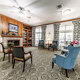A cozy living room with a fireplace, bookshelves, and comfortable seating.