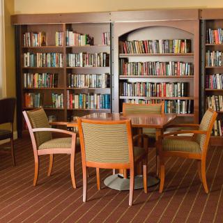 A cozy library corner with bookshelves, a table, and chairs.