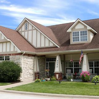 A charming suburban house with a well-maintained lawn and a cozy front porch.