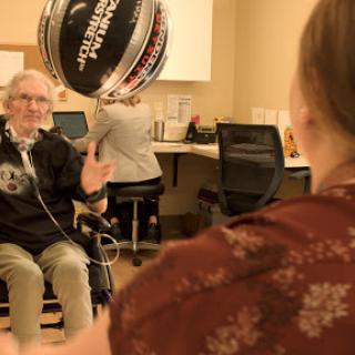 An elderly person engages in a therapeutic activity with a caregiver, highlighting the importance of social interaction in rehabilitation.