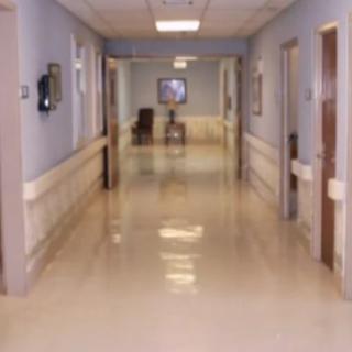 A quiet and clean hospital corridor with doors on either side.