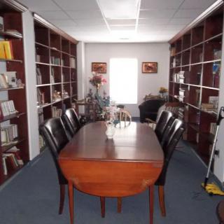 A meeting table surrounded by chairs in a room lined with bookshelves.