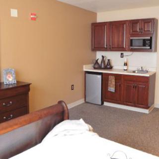 A cozy room with a kitchenette and wooden furniture.