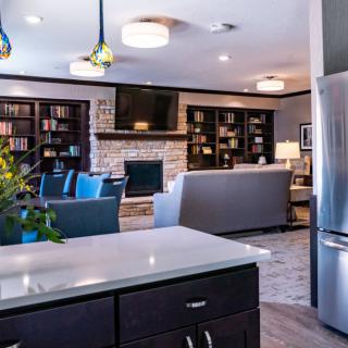 A modern open-plan kitchen and living room featuring sleek furniture and appliances.