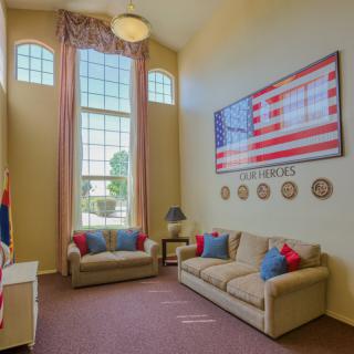A patriotic-themed living room with high ceilings and large windows.