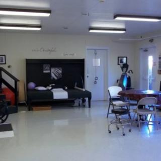 An indoor space with a bed, table, and chairs.