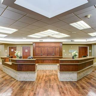 Modern reception area with wooden desk and bright lighting.