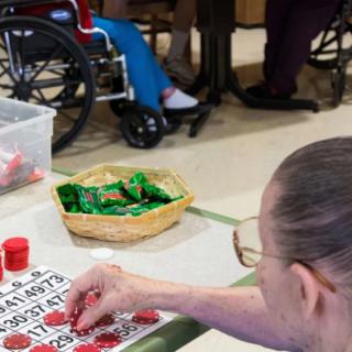 An elderly person playing bingo in a nursing home setting.