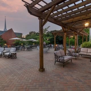 An inviting outdoor patio with comfortable seating and a pergola at sunset.