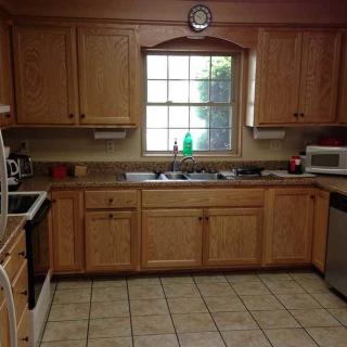 A kitchen with wooden cabinets and a window above the sink.