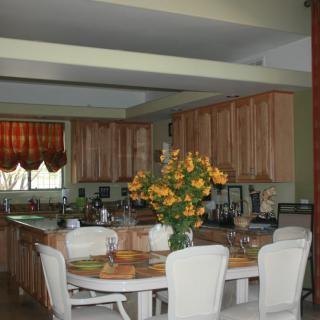 A cozy kitchen and dining area featuring a table with chairs, decorated with a vase of flowers.