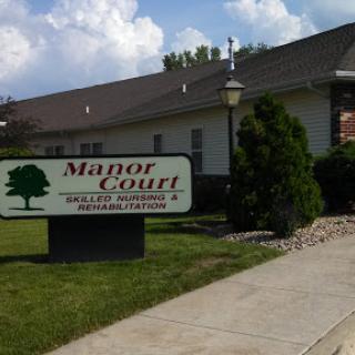 The exterior view of Manor Court, showcasing the building and its sign.