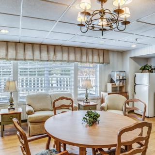 Cozy living and dining space with a round table, comfortable seating, and large windows.