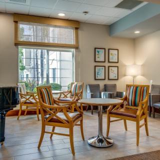 A cozy waiting room with chairs and a table near a large window.