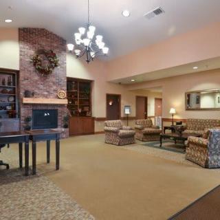 A cozy lobby area featuring comfortable seating, a fireplace, and elegant lighting.