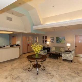 A cozy lobby with comfortable seating and a central table adorned with flowers.