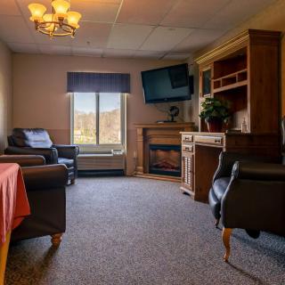 A cozy living room with comfortable seating, a television, and a fireplace.