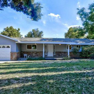 A single-story house with a garage and a spacious front yard on a sunny day.