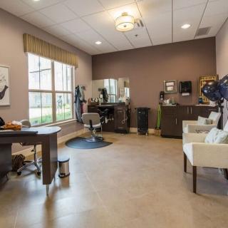 A modern hair salon interior with styling stations, mirrors, and seating.