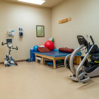 A well-equipped physical therapy room featuring various exercise machines and tools for rehabilitation.