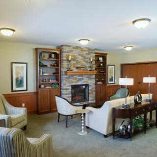 A cozy living room featuring a stone fireplace, comfortable seating, and modern furnishings.