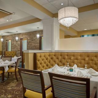 An elegantly designed restaurant interior with neatly arranged dining tables and plush seating.