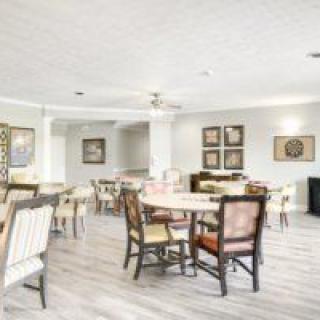 A bright and modern dining room featuring several tables and chairs with neutral decor.
