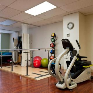 A well-equipped physical therapy room with exercise machines and rehabilitation tools.