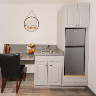 Compact kitchen area with a refrigerator, sink, and seating.