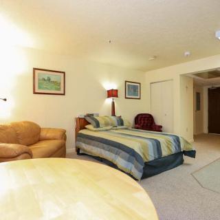 A cozy hotel room featuring a bed, sofa, and warm lighting.