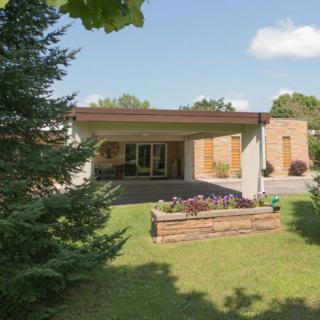A modern house with a spacious backyard featuring a lush lawn and garden.
