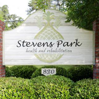 Signage for Stevens Park, a health and rehabilitation facility, surrounded by lush greenery.