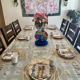 A beautifully set dining table adorned with colorful plates and a floral centerpiece, ready for a special occasion.