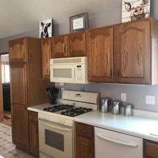 A modern kitchen with wooden cabinets, a stove, and a microwave.
