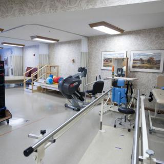 A rehabilitation room equipped with various exercise machines and tools for physical therapy.